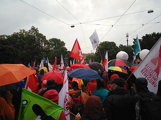 Vielfarbige Schirme und Flaggen, getragen von verschiedenen Demoteilnehmern